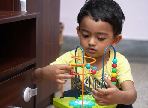 Toddler engaged in fine motor bead maze puzzle